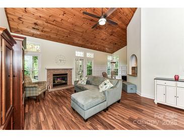 Bright living room with a wood-paneled vaulted ceiling, fireplace, and hardwood floors at 10213 Conistan Pl, Cornelius, NC 28031