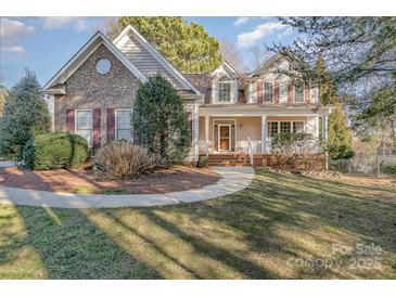 Charming two-story home featuring brick accents, complemented by a well-maintained lawn and mature trees at 125 Cherokee Dr, Mooresville, NC 28117