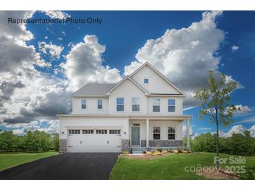 Charming two-story home featuring a two-car garage, light-colored exterior, and beautifully landscaped front yard at 1813 Ab Moore Jr Dr # 3239, Indian Trail, NC 28079