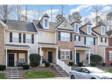 Charming two-story townhome with brick facade, black shutters, landscaped yard, and covered front porch at 8460 Summerglen Cir, Charlotte, NC 28227