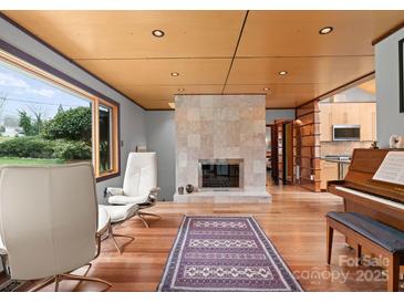 Bright living room with modern fireplace, hardwood floors, ample natural light and refined furnishings at 105 Hillside Dr, Davidson, NC 28036