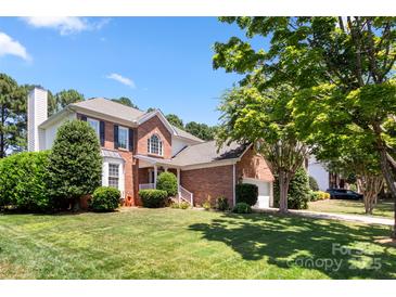 Charming two-story brick home with a well-manicured lawn and lush landscaping at 12541 Willingdon Rd, Huntersville, NC 28078