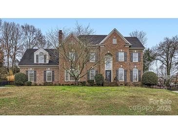 Traditional brick home with symmetrical design, dark shutters, and mature landscaping at 131 Sardis Pointe Rd, Matthews, NC 28105