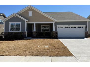 Charming single-story home showcasing a two-car garage, stone accents, neutral siding, and a well-maintained front yard at 2513 Crimson Way, Monroe, NC 28112