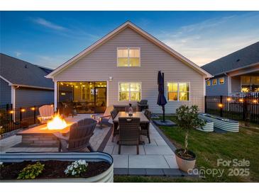 Relaxing backyard features a fire pit and outdoor dining area, perfect for entertaining in the evenings at 4023 Gozzi Dr, Iron Station, NC 28080