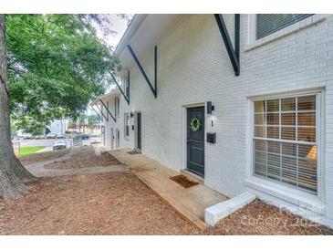 Charming townhouse featuring a white brick exterior and black trim accents at 921 Ambassador St # 1, Charlotte, NC 28208