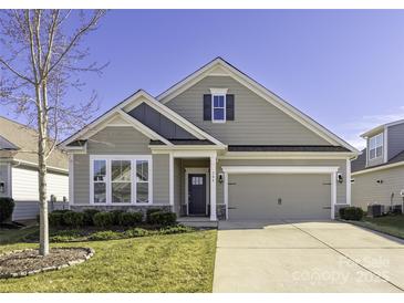Charming one-story home with stone accents, manicured lawn, and attached two car garage at 106 Chase Water Dr, Mooresville, NC 28117