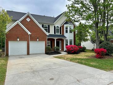 Charming two-story home with a brick facade, lush landscaping, and a two-car garage at 11339 Fox Hill Dr, Charlotte, NC 28269