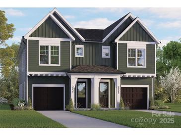 New construction with a two-car garage and green siding, with an inviting walkway to the front doors at 2021 Mandarin Blvd, Charlotte, NC 28205