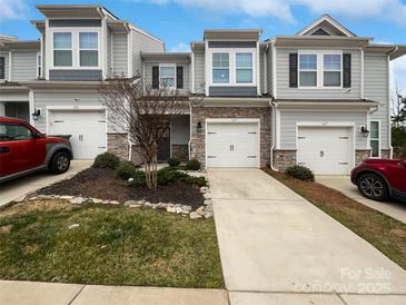 Charming townhome with a stone facade, attached garage, and well-maintained landscaping at 665 Cypress Glen Ln, Clover, SC 29710