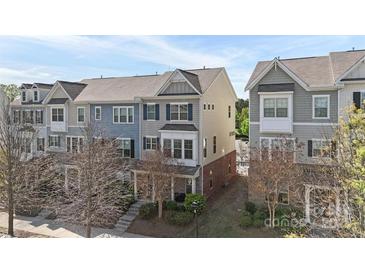 Charming townhome with blue accents, complemented by manicured landscaping and a welcoming front porch at 9330 Ainslie Downs St, Charlotte, NC 28273