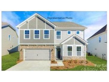 Two-story home featuring gray siding, a brick-lined garage, and a welcoming front porch with stone accents at 149 Saidin Ln, Troutman, NC 28166