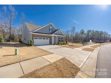 A single-Gathering home boasts a well-manicured lawn, long driveway and two-car garage at 234 Pintail Dr, Monroe, NC 28110