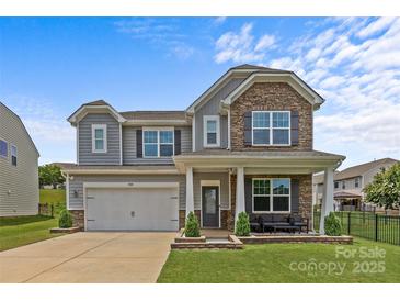 Charming two-story home with stone accents, gray siding, manicured lawn, and inviting front porch at 3008 Dundee Ln, Fort Mill, SC 29707