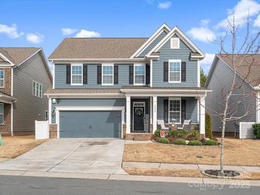 Charming two-story home with blue siding, black shutters, well-manicured lawn, and inviting front porch at 3038 Lydney Cir, Waxhaw, NC 28173
