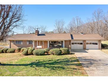 Charming brick home featuring a manicured lawn and inviting covered front porch at 3087 E Nc Hwy 150 Hwy, Lincolnton, NC 28092