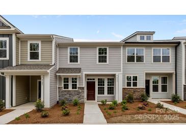 Inviting townhouse showcasing stone accents, gray siding and a well manicured landscape at 4117 Walking Ridge Rd # 55, Charlotte, NC 28208