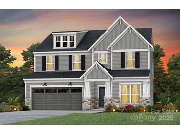 Two-story home featuring gray siding, black shutters, stone accents, and a two-car garage at 1056 Kinship Dr # 113, Lancaster, SC 29720