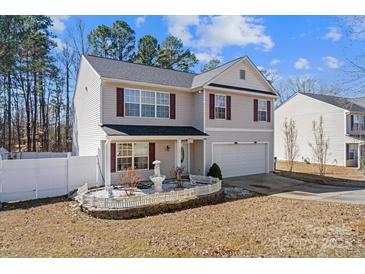 Charming home with manicured landscaping, white picket fencing, and a two-car garage at 10816 Pointer Ridge Dr, Charlotte, NC 28214