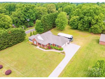 Expansive brick home with long driveway, large RV, well-maintained lawn, and lush tree cover at 119 Era St, Troutman, NC 28166