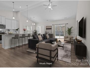 Bright, open-concept living room boasts modern furnishings and a seamless flow to the outdoor patio at 127 Tradesmen Trl, Troutman, NC 28166