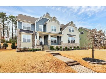 Charming two-story home boasts manicured lawn, stone accents, and a welcoming front porch at 14125 Derby Farm Ln, Charlotte, NC 28278