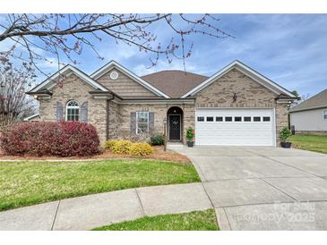 Charming brick home with a manicured lawn, tidy landscaping and a two-car garage at 258 Lagoda Dr, Locust, NC 28097