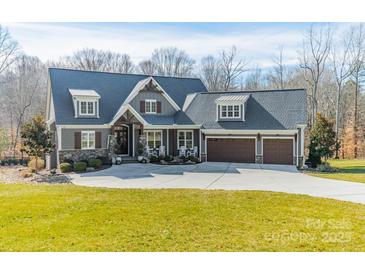 Charming home with a three car garage, rocking chair front porch and well-manicured lawn at 571 Firefly Ln, Iron Station, NC 28080