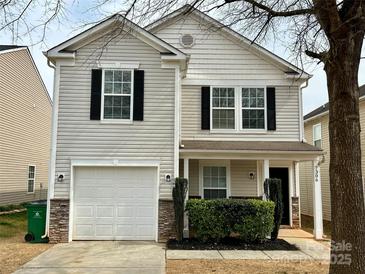 Charming two-story home featuring stone accents, an attached one-car garage, and a cozy front porch at 7306 Fox Point Dr, Charlotte, NC 28269