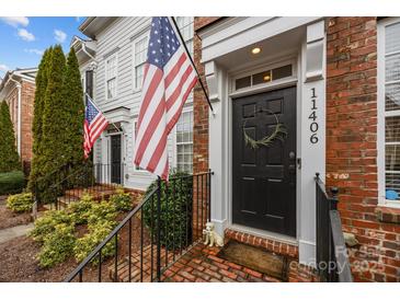 Inviting townhouse entrance featuring brick steps, black door with wreath, and patriotic American flags at 11406 Potters Row, Cornelius, NC 28031