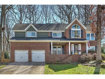 Charming two-story brick home with an attached two-car garage and well-manicured front yard at 12724 Cliffcreek Dr, Huntersville, NC 28078