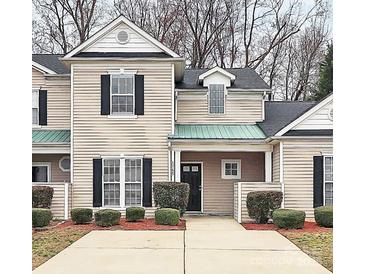 Charming townhome featuring black shutters, well-maintained landscaping, and a cozy covered entryway at 1765 Holliford Ct, Charlotte, NC 28215