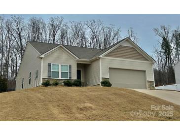 Charming single Gathering home with neutral siding, a two car garage, and manicured landscaping at 2405 Stonehaven Dr, Albemarle, NC 28001