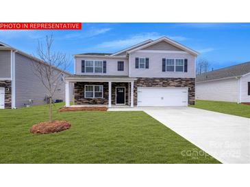 Charming two-story home features a well-maintained lawn and a two-car garage at 106 Woodhall Way, Troutman, NC 28166