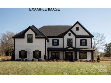 Beautiful two-story home featuring a large front yard and eye-catching black and white trim at 11016 Tyler Brook Ln # Oak0036, Mint Hill, NC 28227