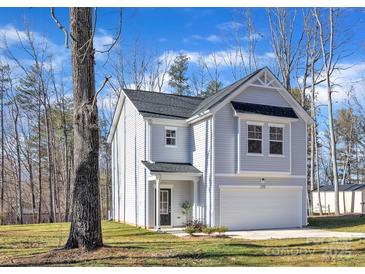 Charming two-story home with an attached garage and manicured lawn against a serene wooded backdrop at 120 Orville Rd, Statesville, NC 28677