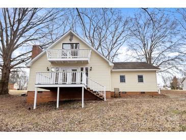 Charming two-story home with yellow siding and multiple decks, perfect for outdoor living and entertaining at 1275 Rocky Creek Rd, Shelby, NC 28152