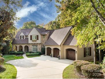 Charming two-story home with a three-car garage and a stone and siding exterior and well-manicured landscaping at 1307 Wyndmere Hills Ln, Matthews, NC 28105