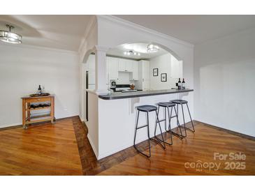 Bright white kitchen with bar seating and open to the living area, great for entertaining at 1323 Queens Rd # 424, Charlotte, NC 28207