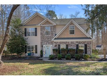 Charming two-story home featuring stone accents, black shutters, and a light blue front door at 15314 Logan Grove Rd, Charlotte, NC 28227