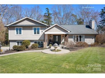 Charming home featuring a manicured lawn, inviting front porch, and beautiful water fountain centerpiece at 19320 Davidson Concord Rd, Davidson, NC 28036