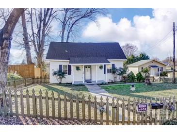 Charming home featuring a manicured lawn, quaint fence, and delightful curb appeal at 305 S Clay St, Gastonia, NC 28052