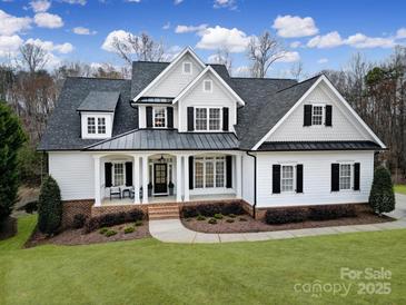 Beautiful two-story home boasts a manicured lawn and a welcoming front porch with classic black shutters and white trim at 411 Belo Ct, Fort Mill, SC 29715