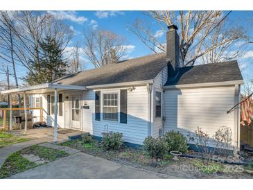 Quaint single-story home showcasing the side yard, chimney, and covered front porch at 800 Woodlawn St, Belmont, NC 28012