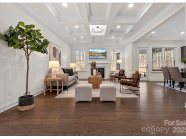 Bright living room featuring a coffered ceiling, fireplace, and hardwood floors at 3078 Montreaux Valley Dr, Fort Mill, SC 29707