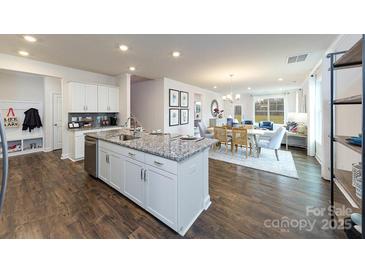 Open concept kitchen features a central island with granite countertops and seamlessly connects to the dining and living areas at 4229 Steel Way, Sherrills Ford, NC 28673