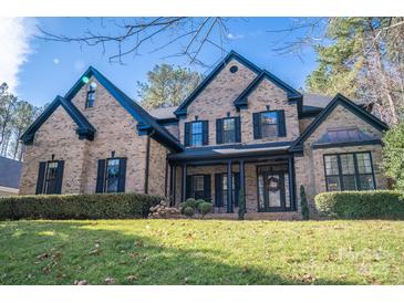 Beautiful brick home featuring a manicured lawn, covered entryway and traditional architectural details at 4268 Rustling Woods Dr, Denver, NC 28037