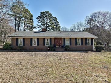 Charming brick home featuring a well-manicured lawn, a classic design, and mature trees at 1026 Norwich Rd, Charlotte, NC 28227