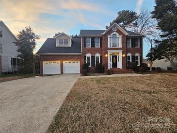 Charming brick home with attached two-car garage and manicured lawn at twilight at 1516 Plantation Trl, Gastonia, NC 28056