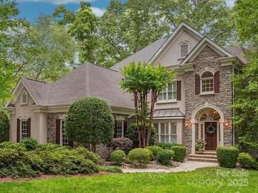 Charming stone and stucco home with mature landscaping and manicured lawn at 4687 Eagle Pointe Ct, Denver, NC 28037